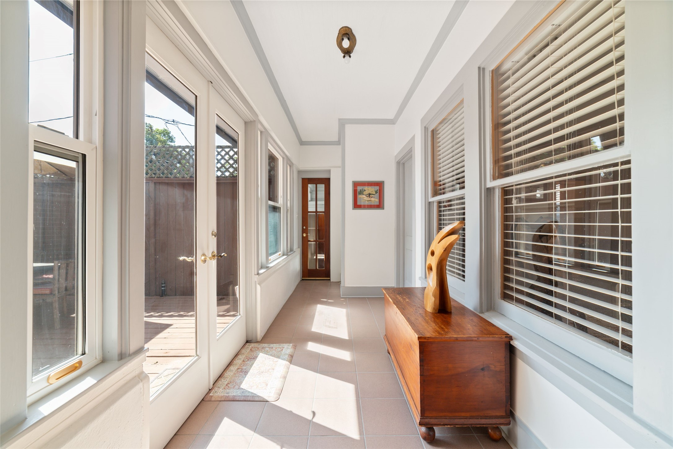 1613 California Street Houston, TX 77006 - Photo 26 of 50 A favorite feature of the home, this glass-lined gallery blurs the line between indoors and out, filling the space with natural light as it gracefully connects the original Craftsman to the private primary suite and outdoor living areas.