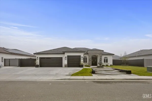 a front view of a house with a garden and parking