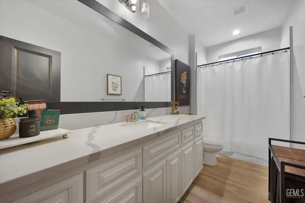 a spacious bedroom with a large bed and a chandelier