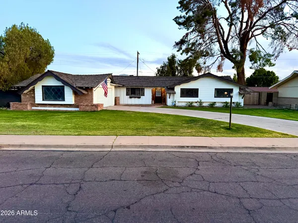 a view of a house with a yard and large trees