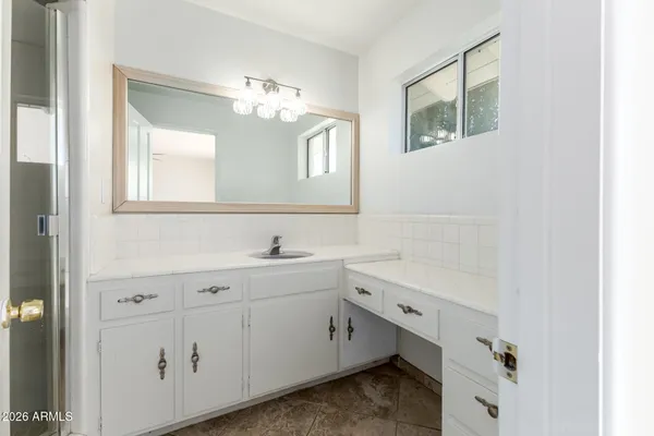 an empty room with wooden floor ceiling fan and windows