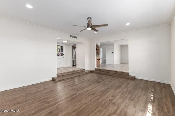 an empty room with wooden floor and windows