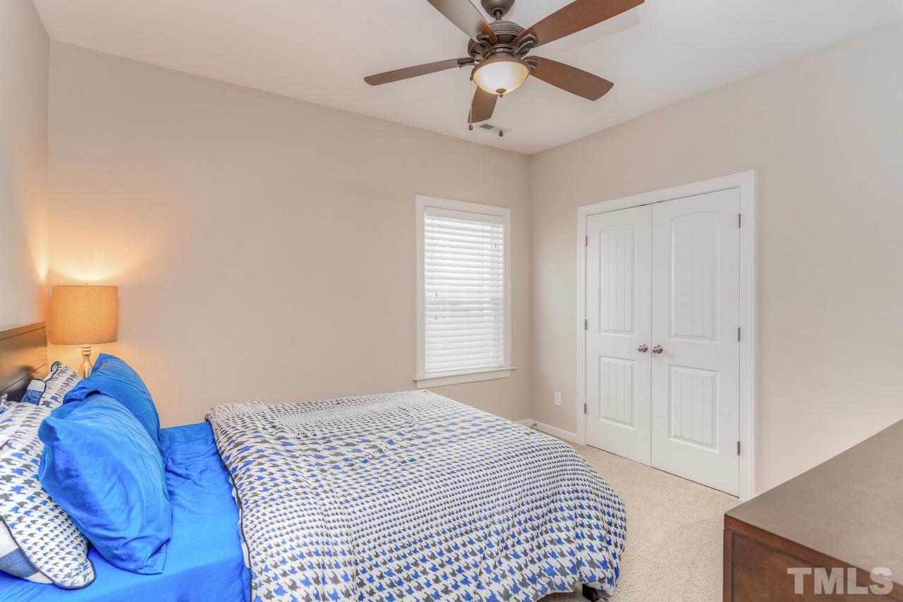 1141 Chapanoke Road Raleigh, NC 27603 - Photo 20 of 25 a bedroom with a bed and a chandelier