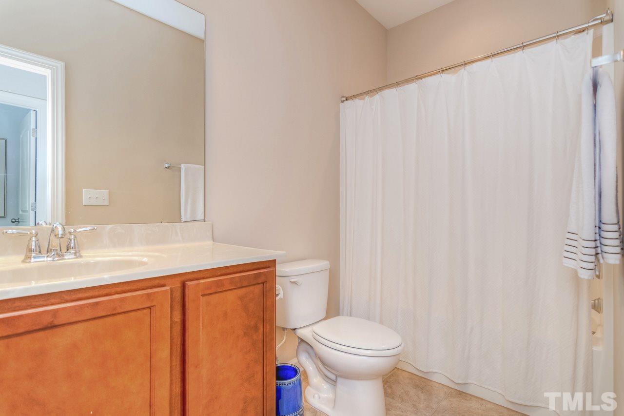 1141 Chapanoke Road Raleigh, NC 27603 - Photo 21 of 25 a bathroom with a sink a toilet and a mirror