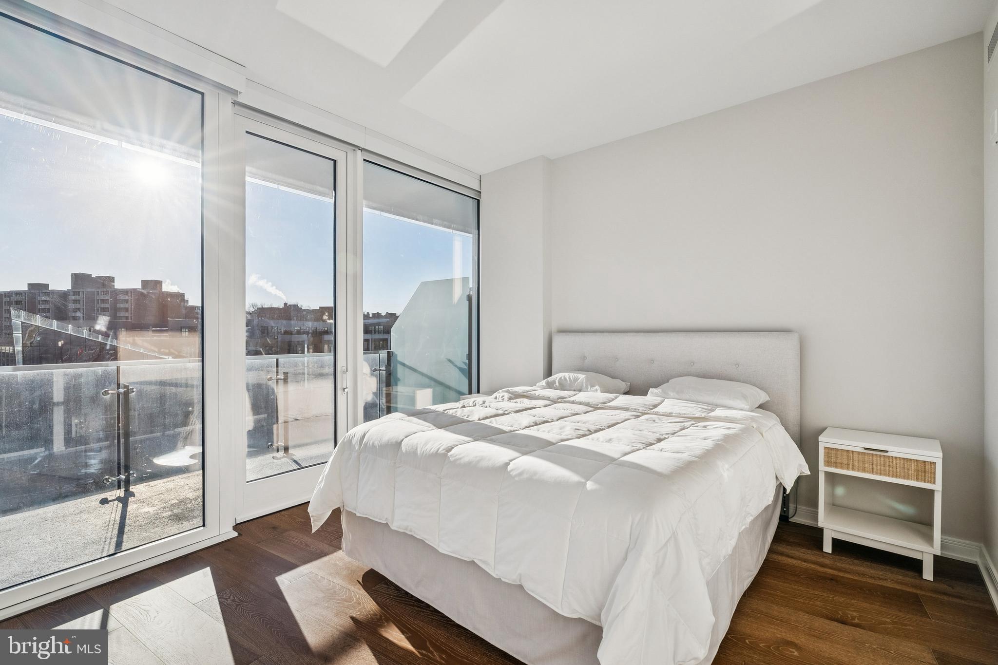 601 Wharf Street Southwest, Unit 504 Washington, DC 20024 - Photo 14 of 39 a bedroom with a bed and a glass window