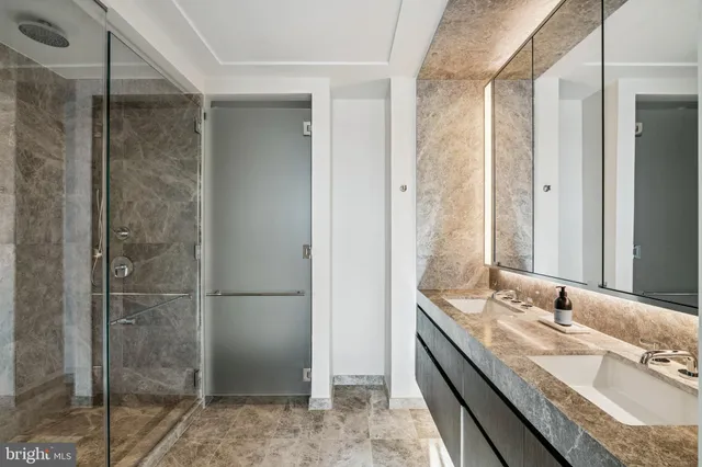 a bathroom with a granite countertop sink mirror and shower