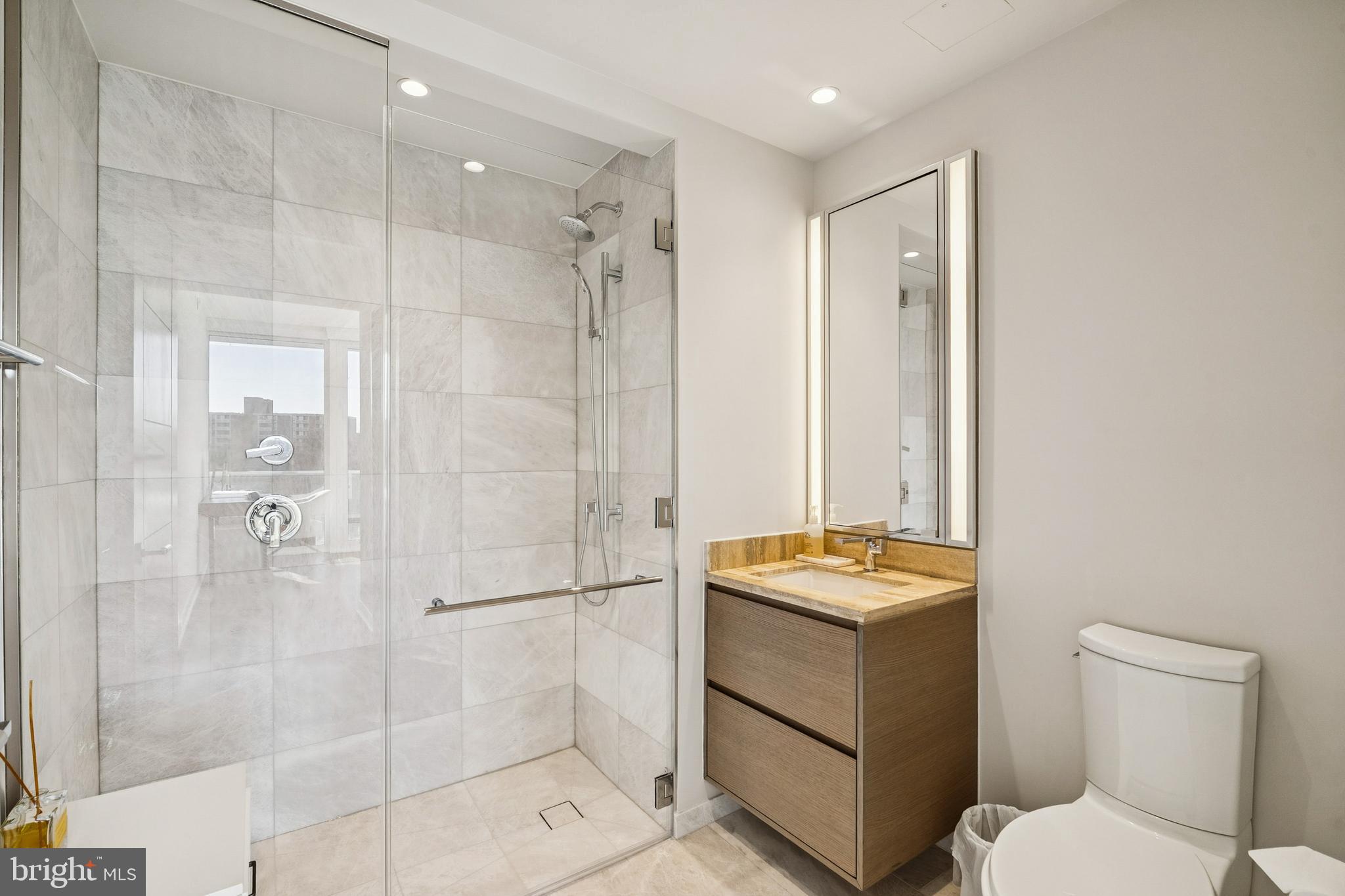 601 Wharf Street Southwest, Unit 504 Washington, DC 20024 - Photo 18 of 39 a bathroom with a granite countertop sink toilet and shower