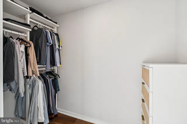 a view of walk in closet with clothes and shoes