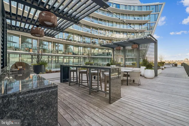 a view of a roof deck with couches and wooden floor