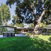 a view of a house with backyard and sitting area