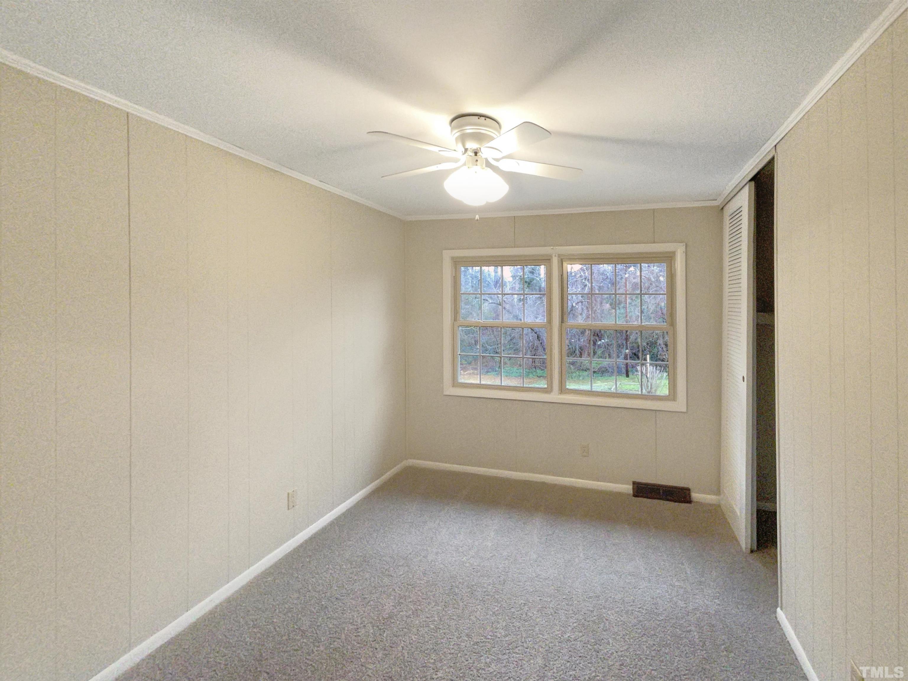 5333 Olive Road Raleigh, NC 27606 - Photo 12 of 18 an empty room with a window and a fan