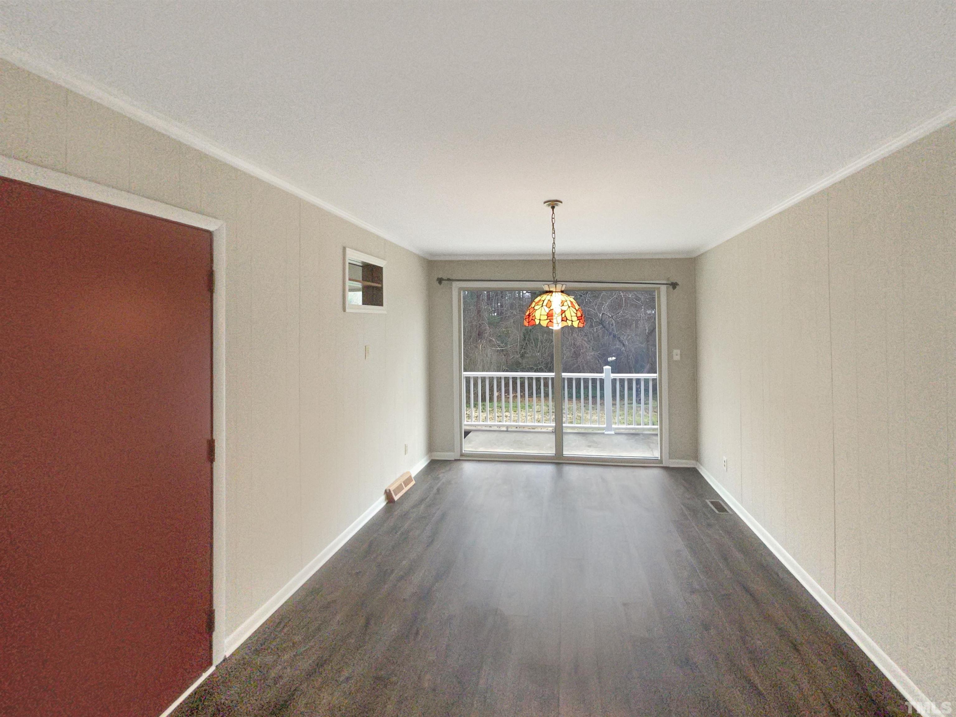 5333 Olive Road Raleigh, NC 27606 - Photo 9 of 18 an empty room with wooden floor and chandelier