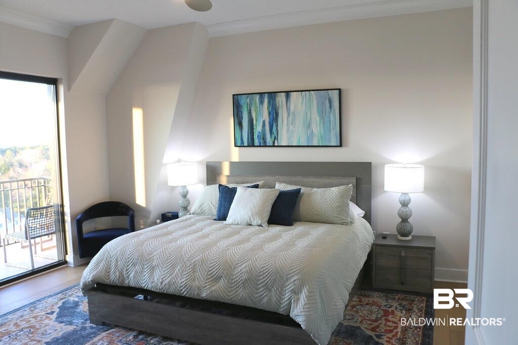 18269 Colony Drive, Unit 803 Fairhope, AL 36532 - Photo 7 of 27 Bedroom featuring access to outside, wood finished floors, and ornamental molding