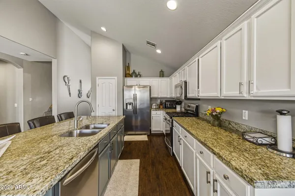 a large kitchen with lots of counter space and wooden floor