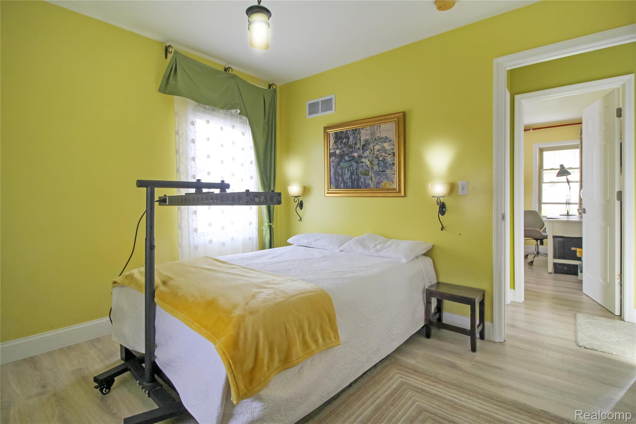 5953 Cooper Street Taylor, MI 48180 - Photo 10 of 33 Bedroom featuring wood-finish flooring, bright yellow walls, a ceiling-mounted light fixture, and wall sconces
