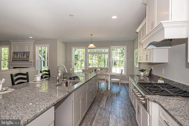 a kitchen with lots of counter top space a stove a sink wooden cabinets and glass door