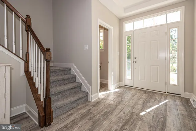a view of a hallway with wooden floor and entryway