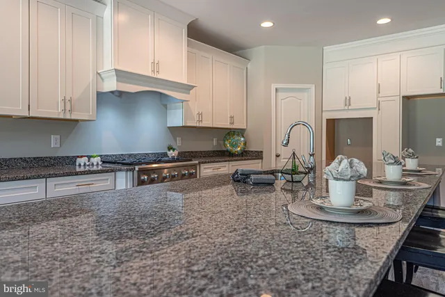 a kitchen with stainless steel appliances granite countertop a stove top oven a sink a counter space and cabinets