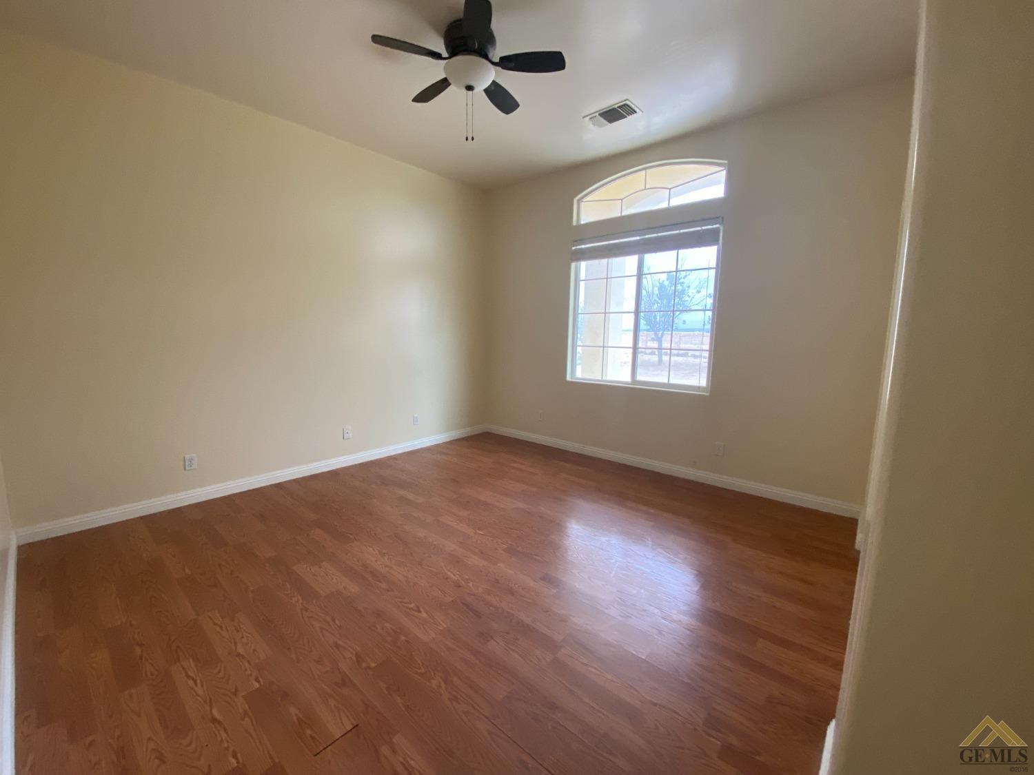 Undisclosed Address Bakersfield, CA 93307 - Photo 13 of 36 a view of an empty room with a window and wooden floor