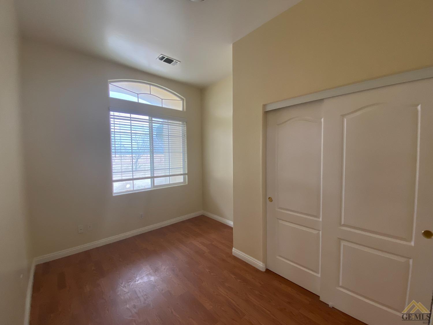 Undisclosed Address Bakersfield, CA 93307 - Photo 18 of 36 an empty room with wooden floor and windows