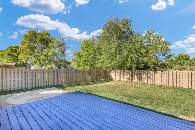 a view of a backyard with wooden fence
