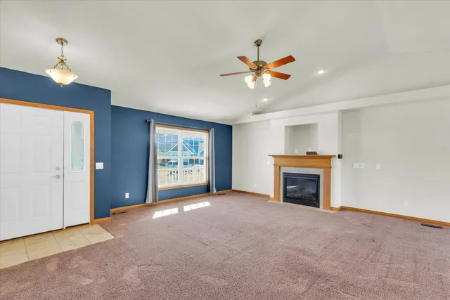 a view of empty room with a fireplace and fan