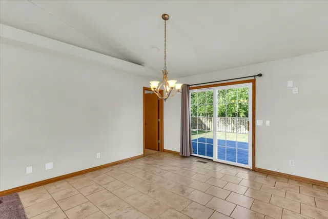 a view of a room with a chandelier projector and a window