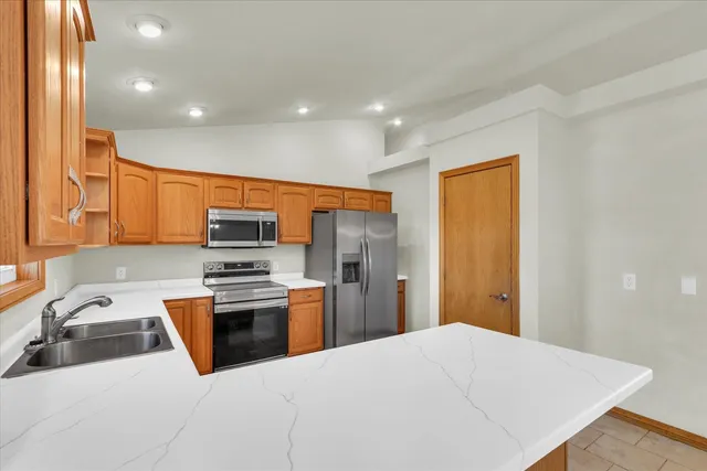 a kitchen with stainless steel appliances a stove top oven a sink and a refrigerator