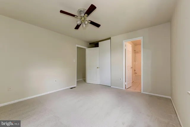 an empty room with a ceiling fan and a window