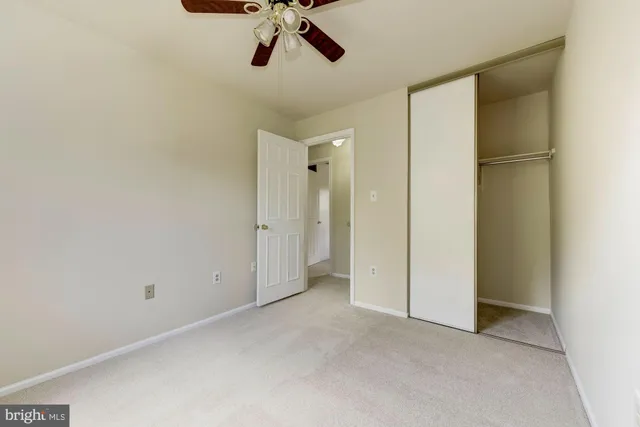 a view of a room with a ceiling fan and closet area