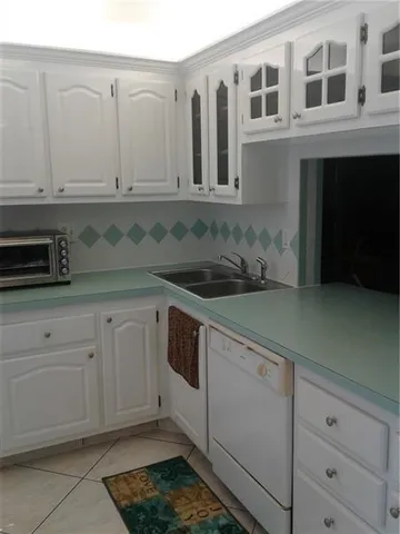 a kitchen with granite countertop white cabinets and sink