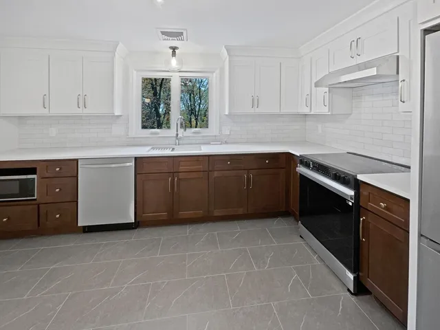 a kitchen with stainless steel appliances granite countertop a stove a sink and a refrigerator