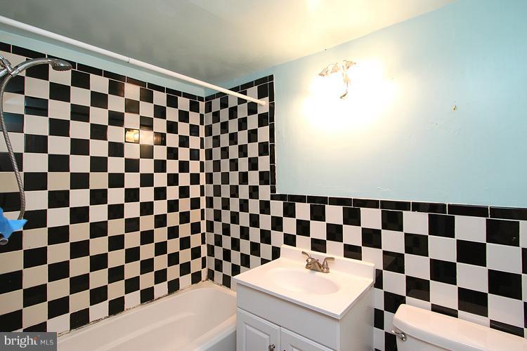 9282 Adelphi Road, Unit 102 Hyattsville, MD 20783 - Photo 19 of 29 a bathroom with a black and white checkered floor