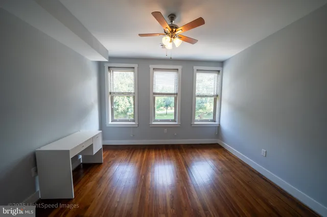 a view of a room with wooden floor and ceiling fan