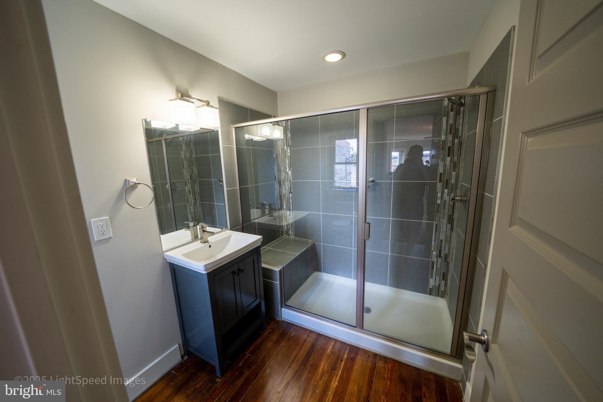 2730 East Baltimore Street Baltimore, MD 21224 - Photo 33 of 40 a bathroom with a shower sink and mirror