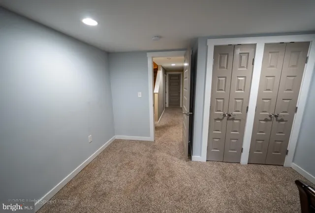 a view of an empty room with a chandelier fan