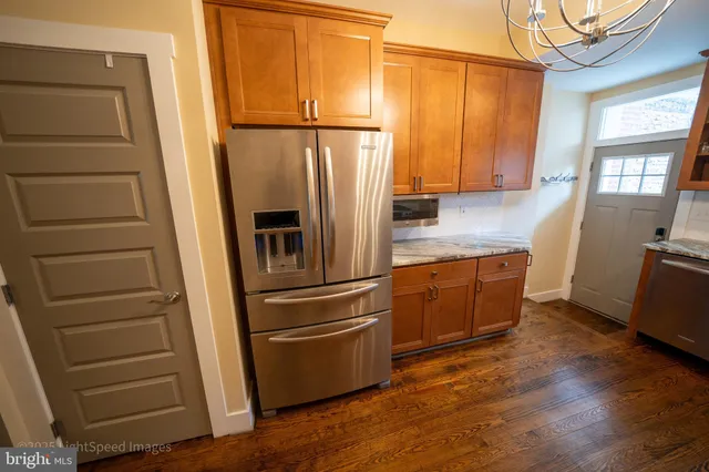 a kitchen with granite countertop wooden floors and stainless steel appliances