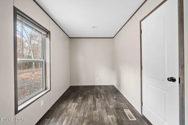 a view of a room with wooden floor and windows