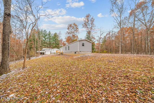 a view of a white house with a yard