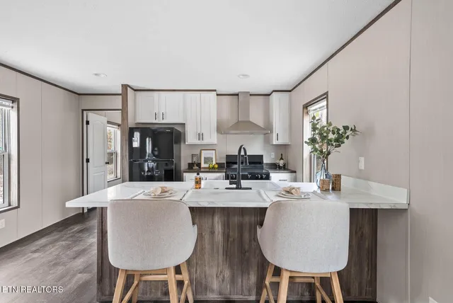 a large kitchen with sink a refrigerator dining table and chairs