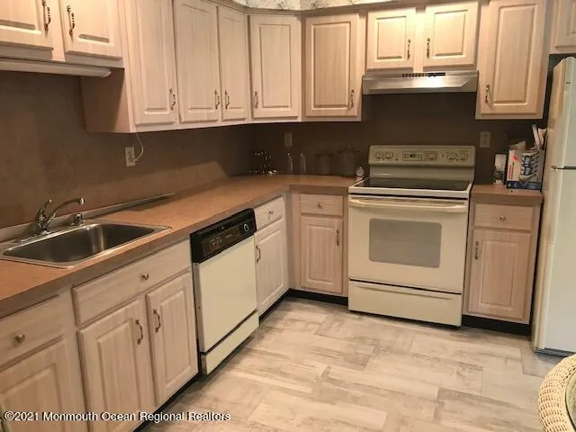 a kitchen with white cabinets and white appliances