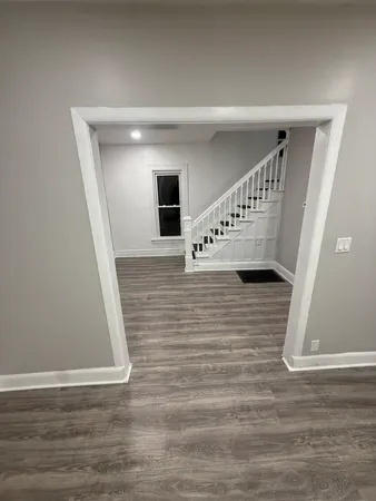 a view of empty room with wooden floor and window