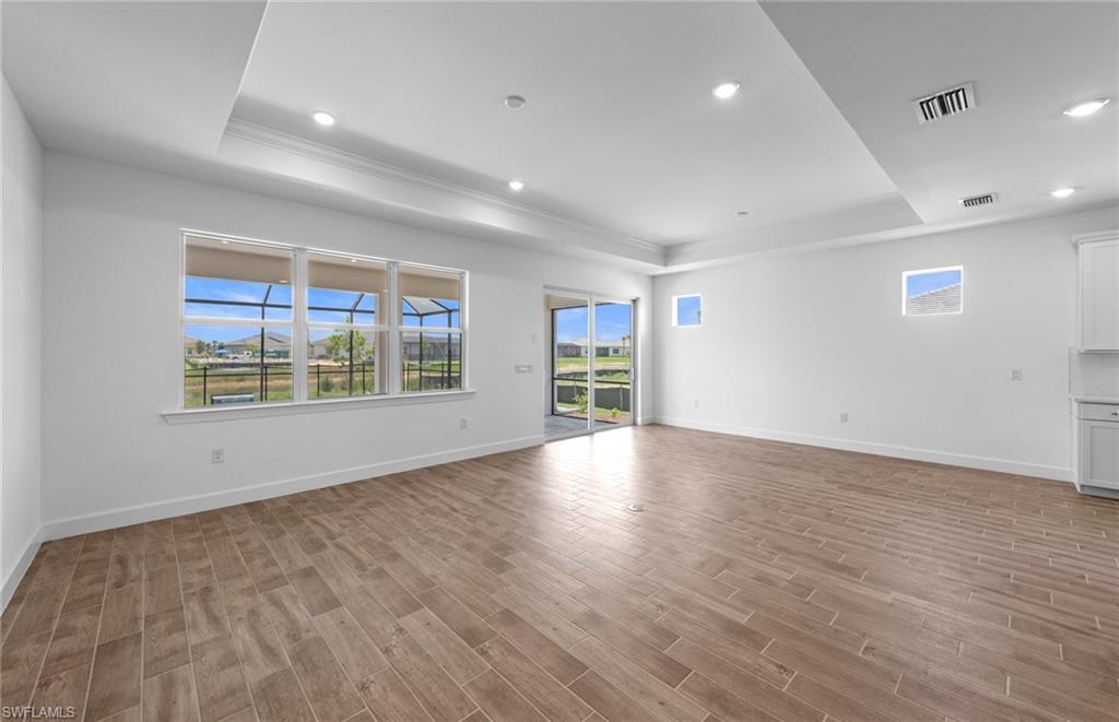 12464 Basalt Lane Alva, FL 33920 - Photo 11 of 28 an empty room with wooden floor and windows