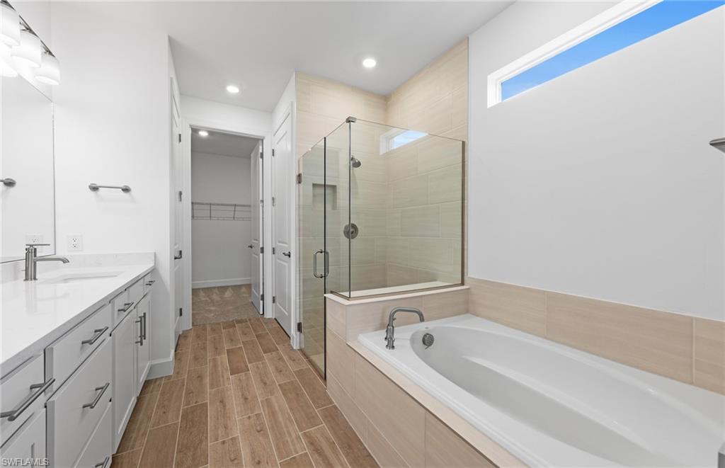 12464 Basalt Lane Alva, FL 33920 - Photo 14 of 28 a spacious bathroom with a granite countertop sink a mirror a bathtub and shower