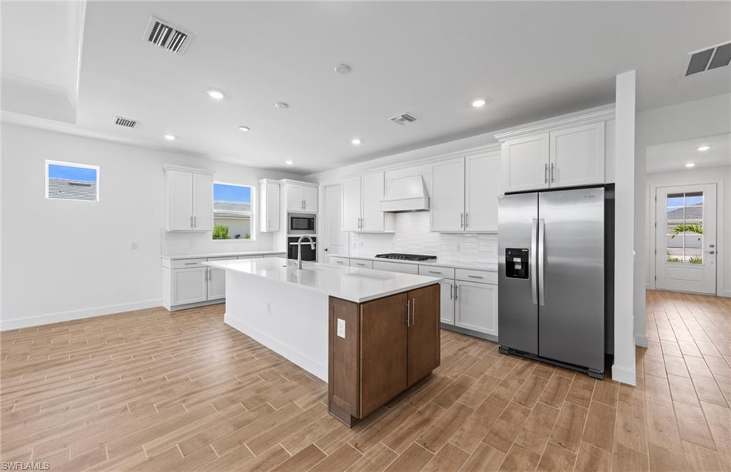 12464 Basalt Lane Alva, FL 33920 - Photo 6 of 28 a kitchen with stainless steel appliances granite countertop a refrigerator a sink and a stove