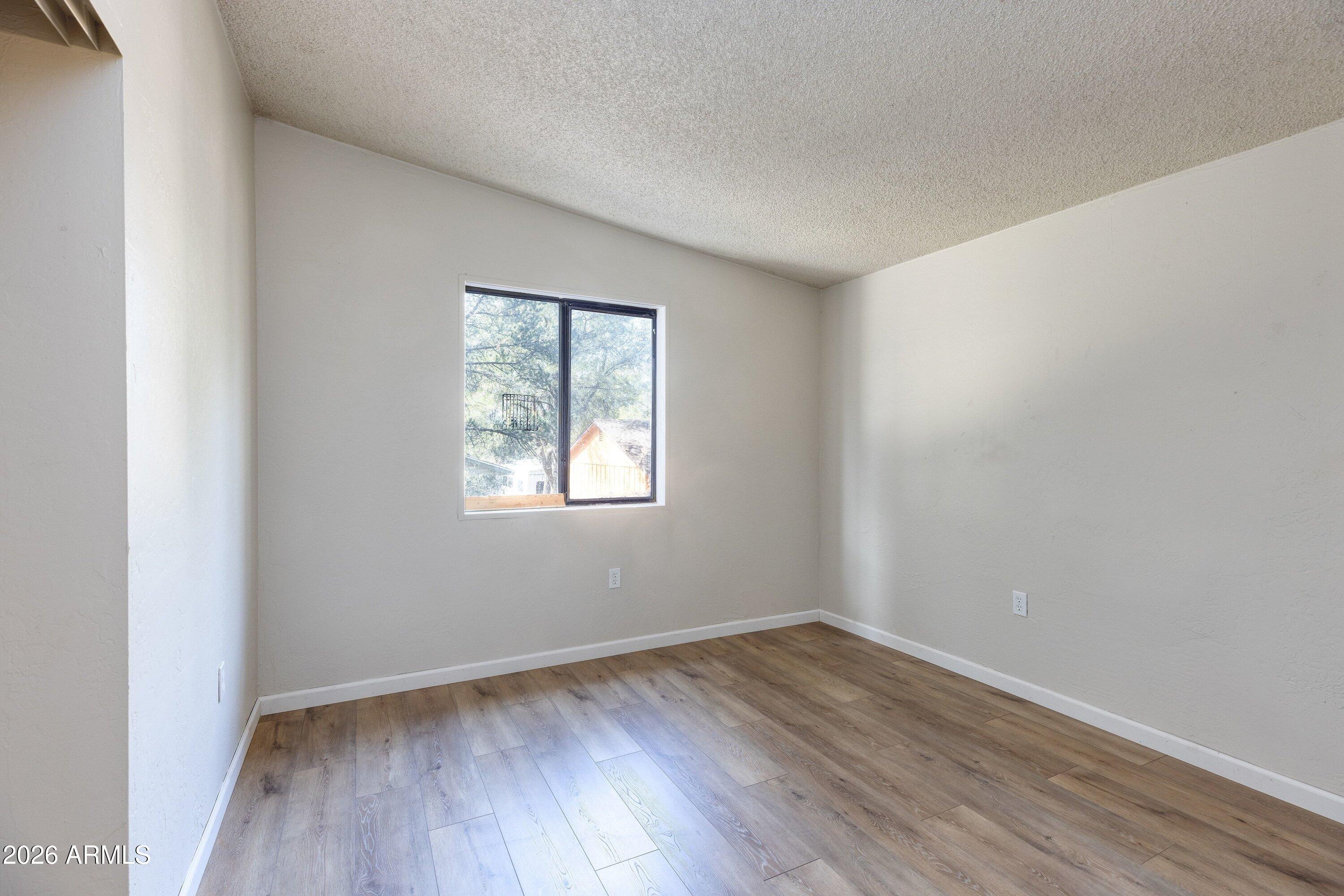 1302 North Matterhorn Road Payson, AZ 85541 - Photo 17 of 27 an empty room with wooden floor and windows
