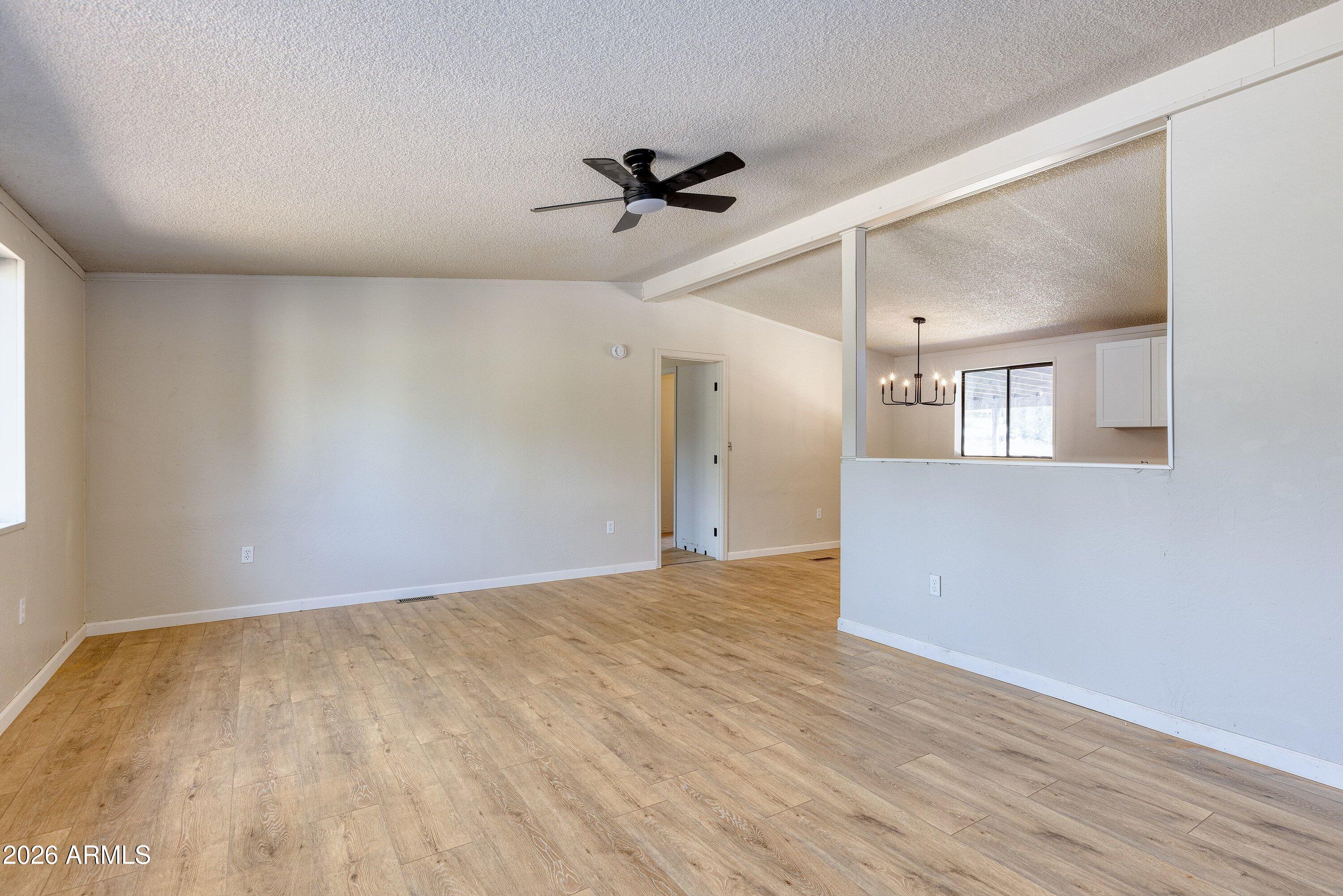 1302 North Matterhorn Road Payson, AZ 85541 - Photo 6 of 27 a view of a big room with wooden floor a ceiling fan and windows