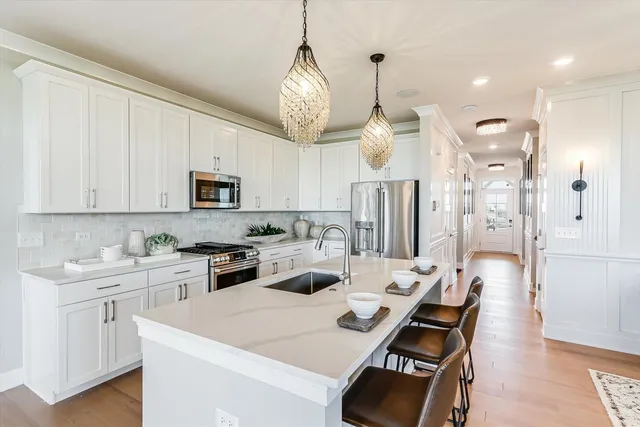 a kitchen with white cabinets and stainless steel appliances
