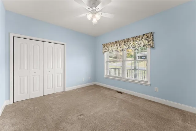 an empty room with a window and a fan