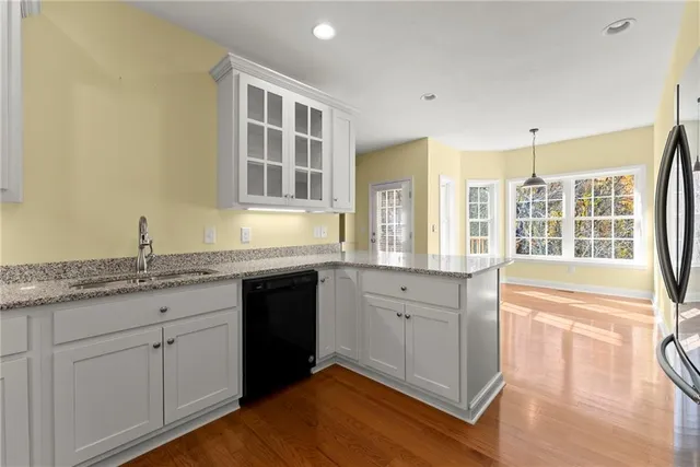 a kitchen with granite countertop a sink dishwasher stove and cabinets